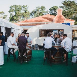 wine barrels and bar stools with party guests sitting around 