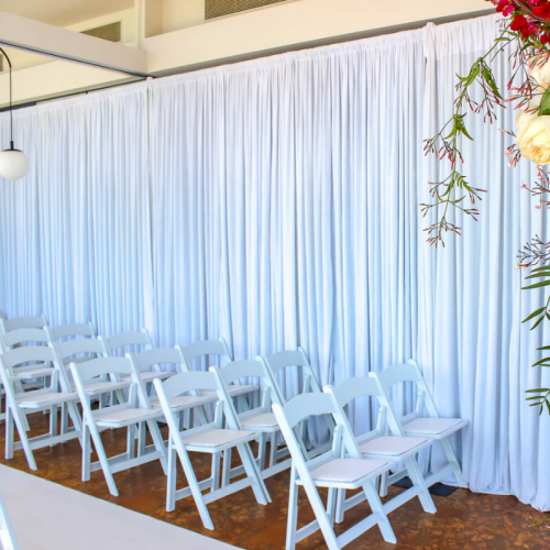 white velvet drape and white padded chairs